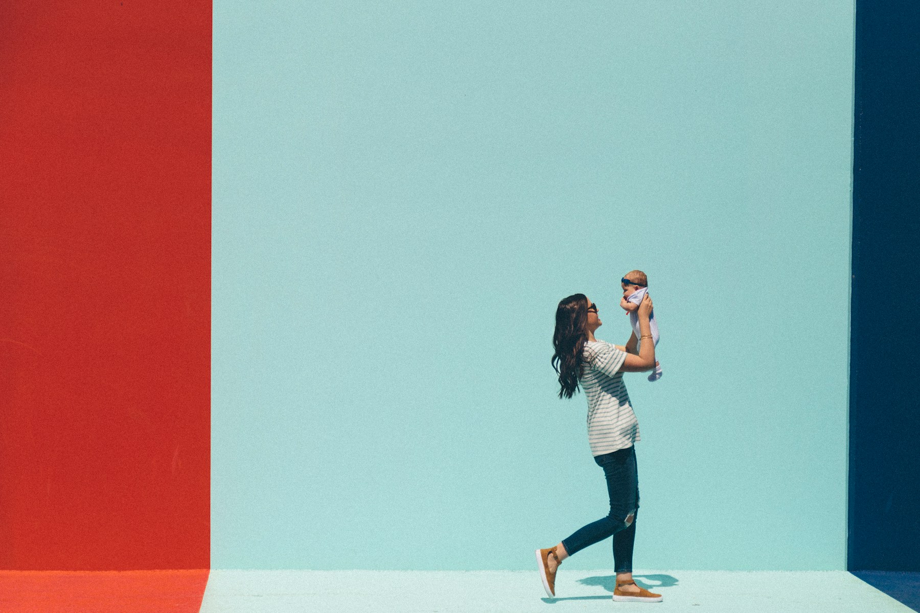 Mother lifting her baby in a colorful family setting